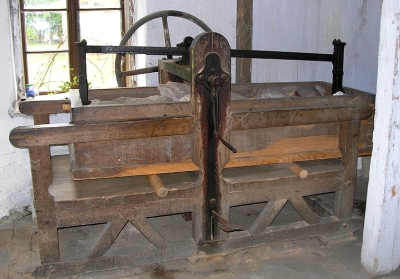 room-size wooden frame with rock-filled box over 2 rollers