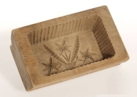 Box-shaped mold with carved floral design on the bottom and grooved sides