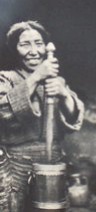 Tibetan woman holding dasher in wooden churn